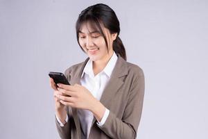 jovem empresária asiática usando telefone no fundo branco