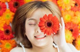 jovem deitada em uma flor com uma expressão feliz foto