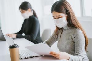 duas mulheres têm que usar máscaras durante o horário de trabalho para se manter seguras durante as epidemias
