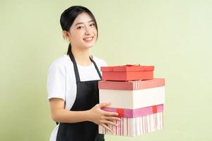 Garçonete asiática segurando uma caixa de presente foto