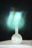uma verde místico luz vem a partir de a químico frasco. foto