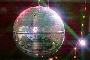 discoteca bola com brilhante feixes, noite festa fundo foto. foto