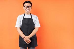 retrato de garçom asiático posando em fundo laranja