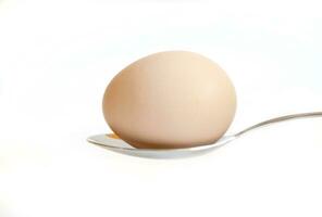 Páscoa ovo manteve em a talheres em uma branco fundo foto