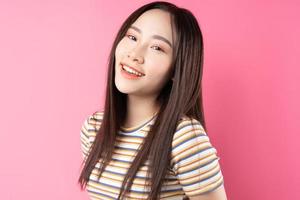 jovem mulher asiática posando em fundo rosa foto