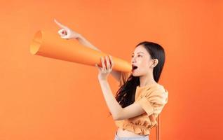mulher asiática usando um alto-falante de papel, conceito anuncia foto