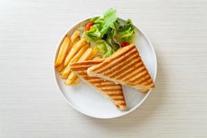 sanduíche de presunto e queijo com ovo e batata frita foto