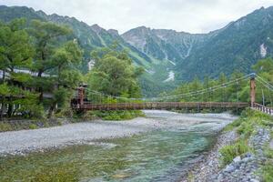 kappa ponte Kamikochi com rio e okuhotaka dia montanha fundo. Kamikochi famoso Lugar, colocar para caminhada e caminhada dentro Matsumoto, Nagano, Japão foto