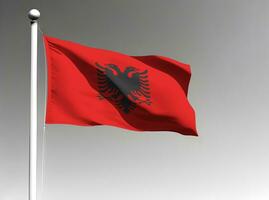 Albânia nacional bandeira acenando em cinzento fundo foto
