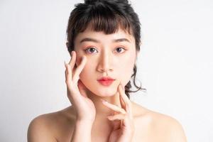 jovem mulher asiática com linda pele em fundo branco foto
