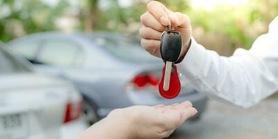 alugar, alugar carro, vender, comprar. o gerente da concessionária envia as chaves do carro para o novo proprietário. vendas, empréstimo de crédito financeiro, aluguel de veículo, seguro, aluguel, vendedor, negociante, prestação, negócio de cuidados com o carro foto