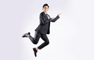 jovem empresário asiático pulando sobre fundo branco foto