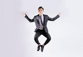 jovem empresário asiático pulando sobre fundo branco foto