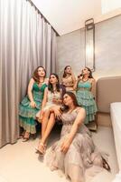 uma grupo do ásia mulheres dentro glamouroso e luxuoso roupas estão sentado em a sofá com seus amigos depois de festa foto