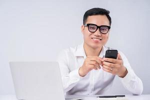 empresário asiático usando smartphone em fundo cinza