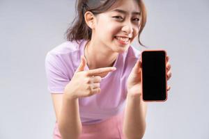 jovem mulher asiática mostrando a tela em branco do smartphone