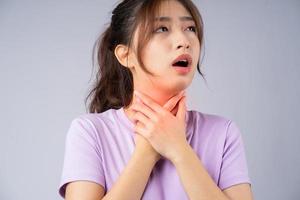 jovem asiática está com dor de garganta foto