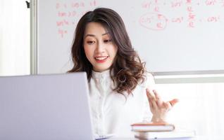 professora asiática ensinando online em casa foto