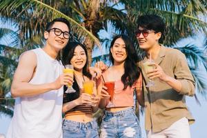 um grupo de jovens asiáticos aproveita uma viagem ao mar nas férias de verão