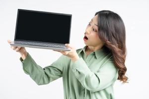 retrato da bela mulher de negócios asiática olhando para a tela do laptop com uma expressão de surpresa foto