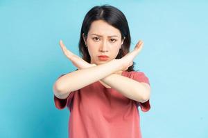 linda mulher asiática fazendo um x com a mão com uma cara zangada