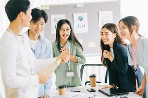 empresário asiático está abrindo champanhe para celebrar o ano novo com os membros do grupo empresarial foto