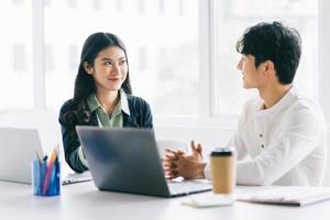 dois jovens empresários asiáticos discutem o projeto de fim de ano foto