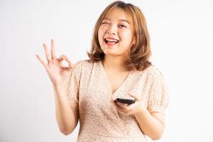 jovem asiática segurando o telefone com expressões, gestos no fundo