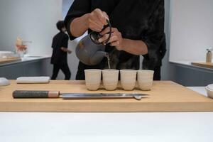 profissional chefe de cozinha preparando e cozinhando cru fresco peixe ingrediente em a mesa com faca para delicioso Sushi e sashimi refeição, pessoa fazer luxo omakase bem jantar japonês Comida restaurante jantar foto