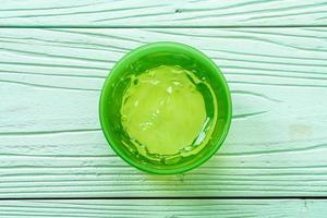 gel de aloe vera com aloe vera cortado em fundo de madeira foto