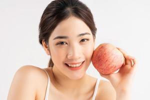 retrato de uma jovem asiática com uma maçã foto