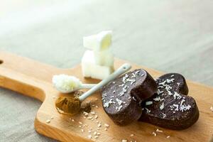 em a mesa lá estão feito à mão chocolates fez do coco óleo, coco salgadinhos e cacau. sobremesa de acordo com para a receita do apropriado nutrição. foto