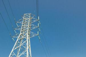 Alto Voltagem a sobrecarga poder linha é uma estrutura usava dentro elétrico poder transmissão e distribuição em pé contra azul céu dia. foto