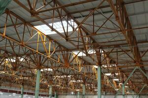 interior do esvaziar fábrica. moderno Projeto do armazém industrial prédio. urbano loft estilo em oficina espaço com metal construções e tubos debaixo a Beton teto. aço cobertura quadro, Armação foto