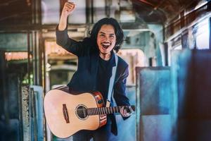 homem tocando guitarra rock tão animado, música, entretenimento, homem tocando guitarra no trem foto