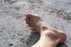 a jovem do homem pés flutuou em uma diferente cimento chão. pés estão não forte, precisar para estar Cuidado foto