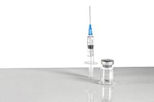 seringa e frasco com vacina de coronavírus, dose de frasco de injeção em um fundo cinza. prevenção, conceito médico, imunização covid-19. foto