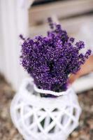 pilha de buquês de flores de lavanda em um banco de madeira velho em um jardim de verão. buquê de lavanda foto