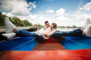 o amor é tudo o que importa. vista superior do lindo casal jovem tomando selfie usando telefone inteligente enquanto estava deitado no barco. história de amor. foto