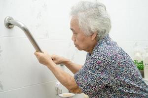paciente asiático sênior ou idosa senhora idosa usar banheiro banheiro lidar com segurança na enfermaria do hospital de enfermagem, conceito médico forte saudável.