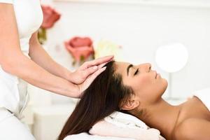 mulher recebendo massagem na cabeça no centro de bem-estar spa. foto