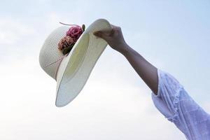 chapéu na mão mulher na praia foto