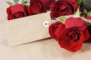 rosas vermelhas com etiqueta de papel em branco em papel pardo foto