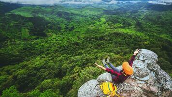 mulher asiática viajar relaxar no feriado. ver a natureza da montanha nas falésias. foto