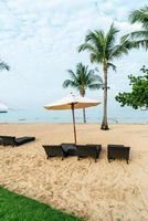 cadeira de praia vazia com palmeiras na praia com fundo do mar
