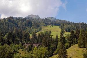 uma pitoresca paisagem alpina com uma velha ponte ferroviária. Áustria. foto
