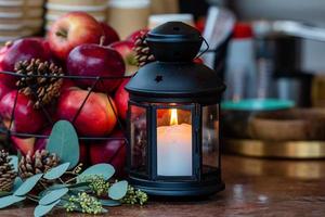 Lanterna de vela acesa e cesta de maçãs na mesa do mercado de natal em riga, letônia