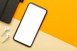 smartphone com maquete de tela em branco na mesa de trabalho foto