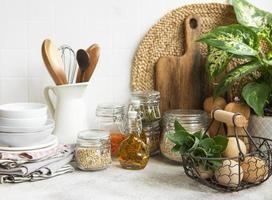 utensílios de cozinha, ferramentas e louças na parede de azulejos brancos de fundo. foto