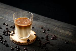 copo de café com leite, café com leite no fundo de madeira foto